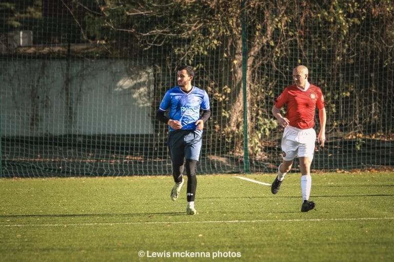 Salah Missi of Krakow Dragoons FC next to a FC United of Manchester oppponent