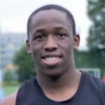 Keanu Solomons of Krakow Dragoons FC smiling while posing for a photo holding a football during a training
