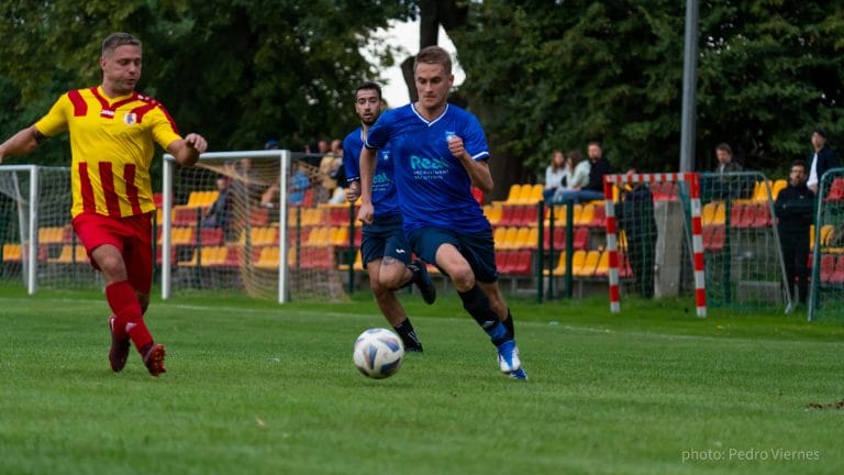 Rob Smits of Krakow Dragoons FC sprinting with the ball with a Zwierzyniecki opponent behind