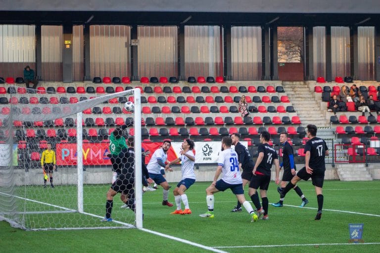 A loose ball from a corner kick inside Podgórze's box just before a Krakow Dragoons FC goal