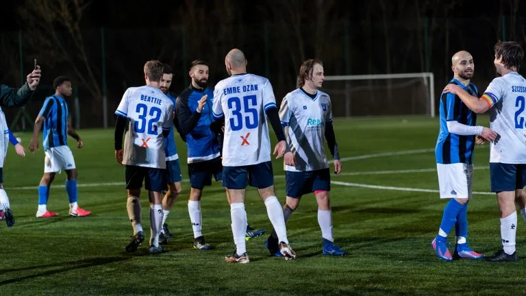 Players of Krakow Dragoons FC and Afc DWS greeting each other after the match