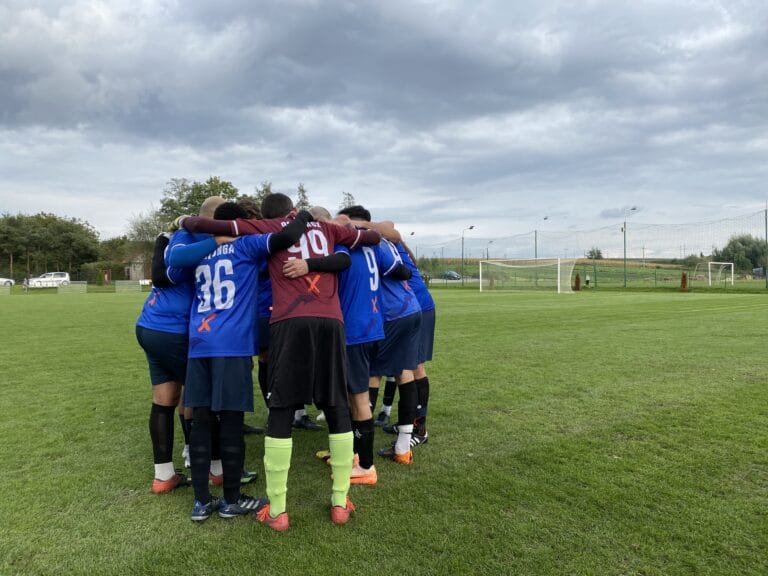 Krakow Dragoons FC players gather in a circle pre-match