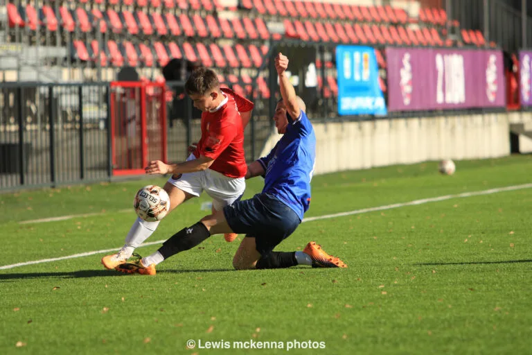 Sasha Arshakian of Krakow Dragoons FC tackles a FC United of Manchester opponent