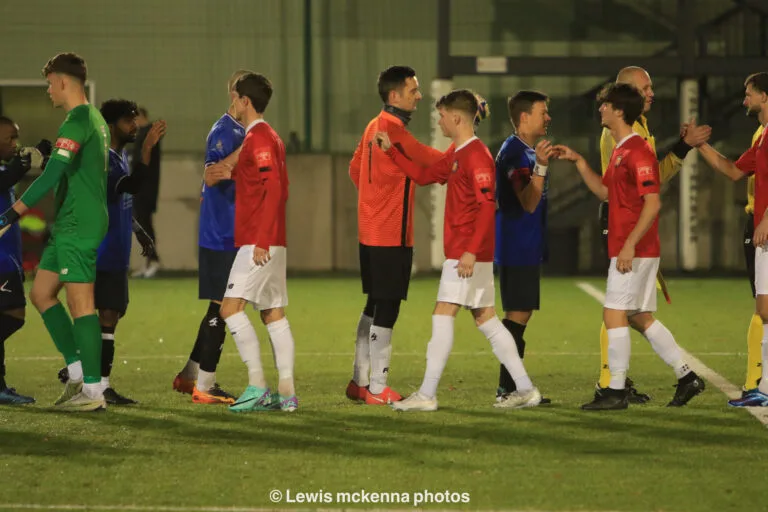 Referees and players of Krakow Dragoons FC and FC United of Manchester greet before match