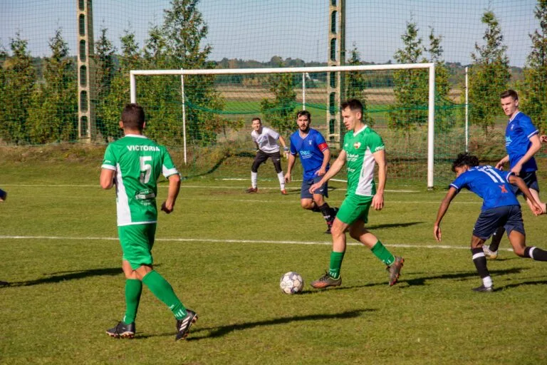Victoria Smroków players exchanging the ball outside Krakow Dragoons FC box