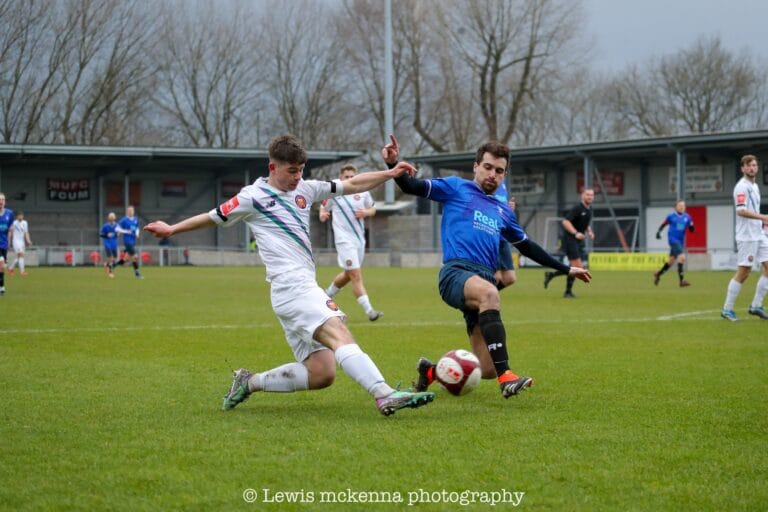 Simon Calabrese of Krakow Dragoons FC disputing a ball with a FC United of Manchester player inside the box