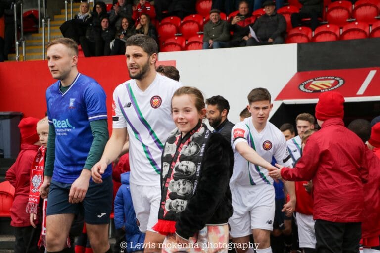 Krakow Dragoons FC and FC United of Manchester players entering the stadium accompanied by children