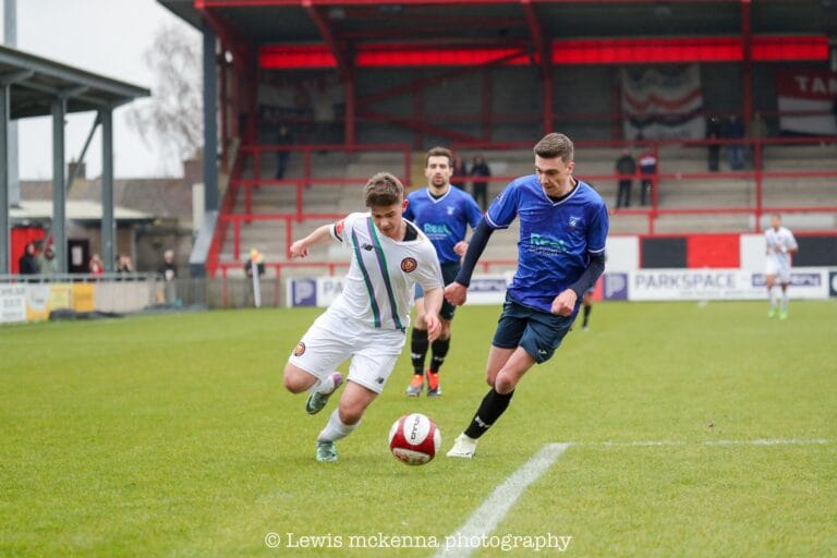 Brian Lemmen of Krakow Dragoons FC chases a FC United of Manchester player carrying the ball