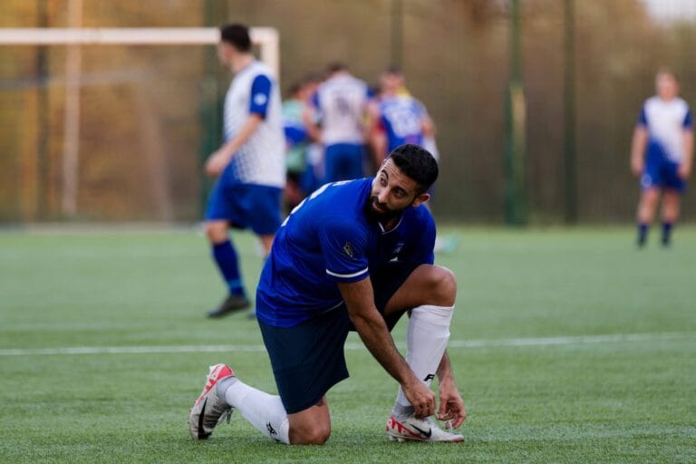 Francesco Leuci of Krakow Dragoons FC tying up his boots