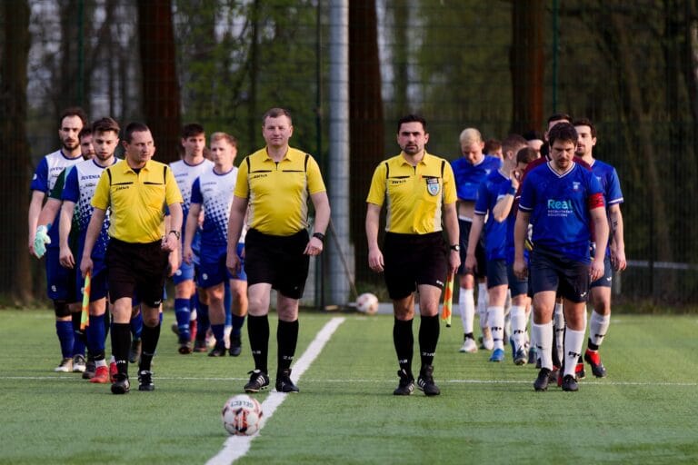 Krakow Dragoons FC and Juvenia Prandocin players, as well as referees enter the field