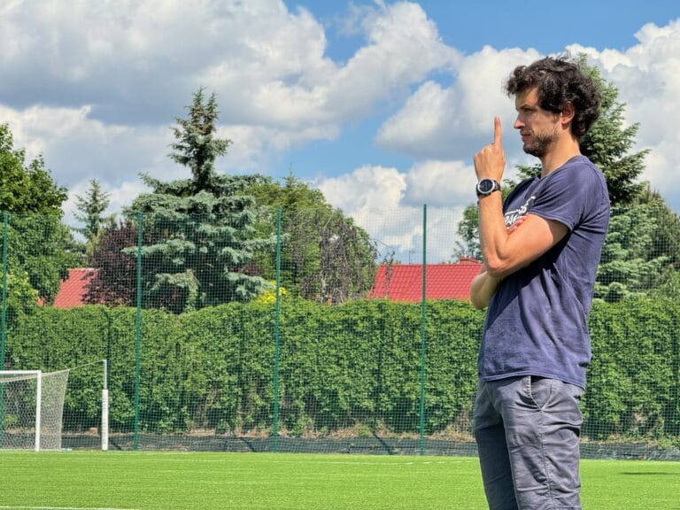 Krakow Dragoons FC head coach Hugo Cruz pointing a finger up, giving instructions to his player