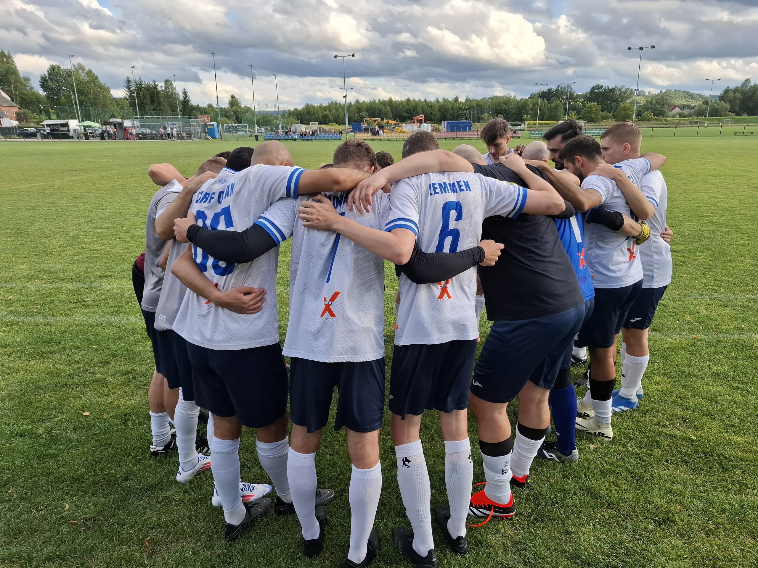 Krakow Dragoons FC players gather in a huddle before match