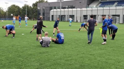 Krakow Dragoons FC players doing warmup exercises, while dialoging with their coaches