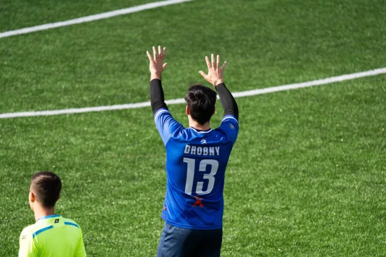 Kuba Drobny of Krakow Dragoons FC raising both arms up