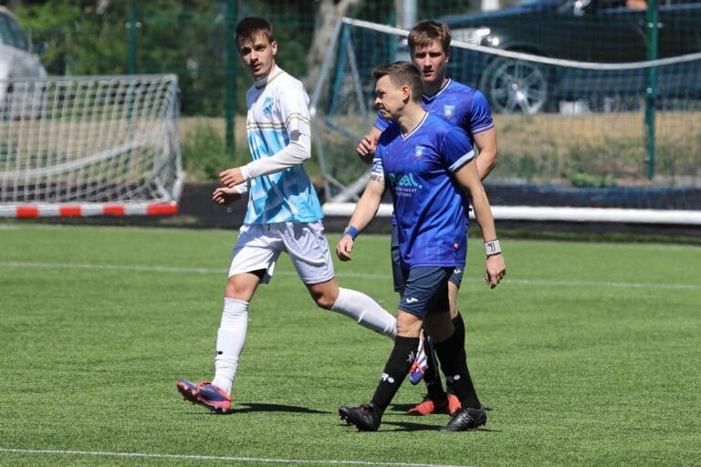Enrico Forabosco and Jan Kołodzieski of Krakow Dragoons FC walking next to an opponent