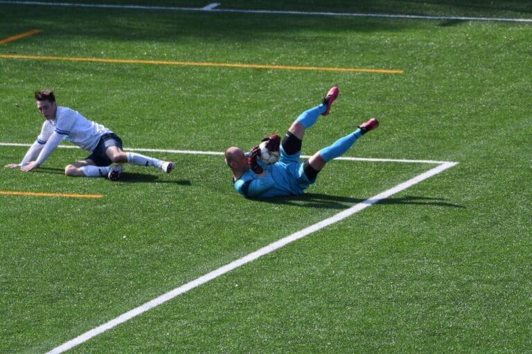 Martin Voženílek of Krakow Dragoons FC in on the floor after a ball dispute with Iskra Radwanowice's goalkeeper