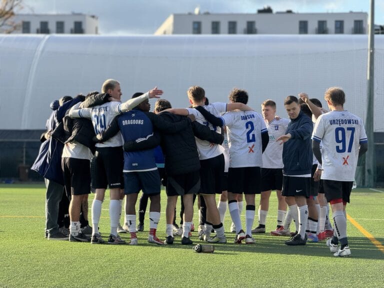 Krakow Dragoons FC players gather in a circle after match