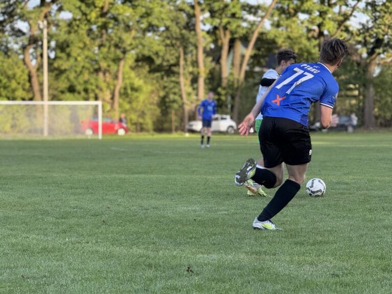 A Krakow Dragoons FC player runs after an opponent carrying the ball